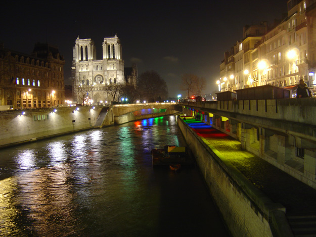 View of Notre Dame at night from the Seine in Paris, France